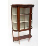 An Edwardian mahogany and boxwood strung display cabinet with glazed door and rounded sides