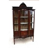 An Edwardian mahogany and inlaid display cabinet with domed back and bowfronted central section