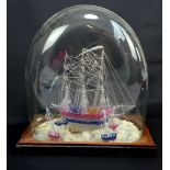 A spun glass model of a three masted ship with four smaller boats around the sides,