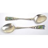 A pair of Arts and Crafts Edwardian hallmarked silver and enamel decorated coffee spoons,