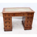 A mahogany kneehole desk of small proportions with arrangement of nine drawers on castors,