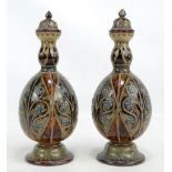 A pair of Doulton Lambeth floral and bead decorated bottle vases with knopped necks and covers,