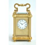 A French brass carriage clock of small proportions, the enamelled dial set with Roman numerals,