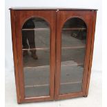 A mahogany bookcase with pair of glazed doors on bun feet, 120 x 144cm.