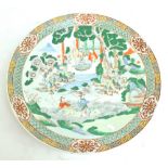 A late 19th century Chinese porcelain charger, painted in enamels with figural scene in landscape,