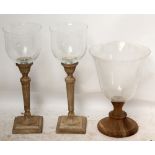 A pair of clear glass lanterns on fluted wooden bases, height 72cm,