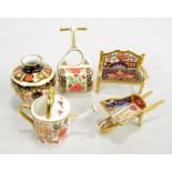 Five Royal Crown Derby miniatures including a watering can, roller and a wheelbarrow (5).