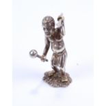 A small silver figure in the form of an African tribesman with knobkerrie and spear,