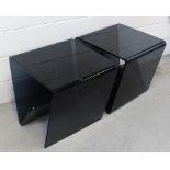 A pair of contemporary transparent black glass tables with magazine rack fold, 50 x 50cm (2).