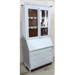 A mid-20th century oak bureau/bookcase with leaded glazed upper section over a fitted bureau and