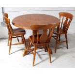 A contemporary circular beech kitchen table on central column support to tripartite base,