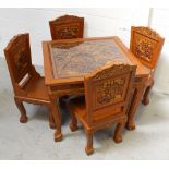 An Indonesian stained table and chairs with relief carved elephants in rainforest to the seat backs