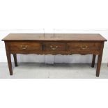 A 19th century three-drawer dresser with shaped apron, of dowel and tenon construction,