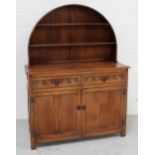 A 20th century oak dresser with domed plate rack and two drawers above cupboard doors, width 120cm.