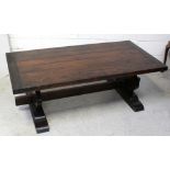 A hardwood Spanish-style coffee table with metal stud decoration on shaped slab-end supports,