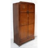 An early-to-mid 20th century oak Arts and Crafts style wardrobe,