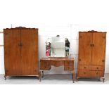 A c1930s walnut three-piece bedroom suite comprising dressing table, wardrobe and tallboy (3).