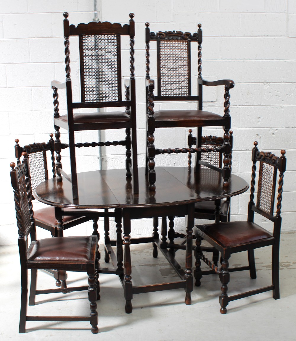 A late 19th/early 20th century oak drop-leaf table on turned legs and a set of six cane-back