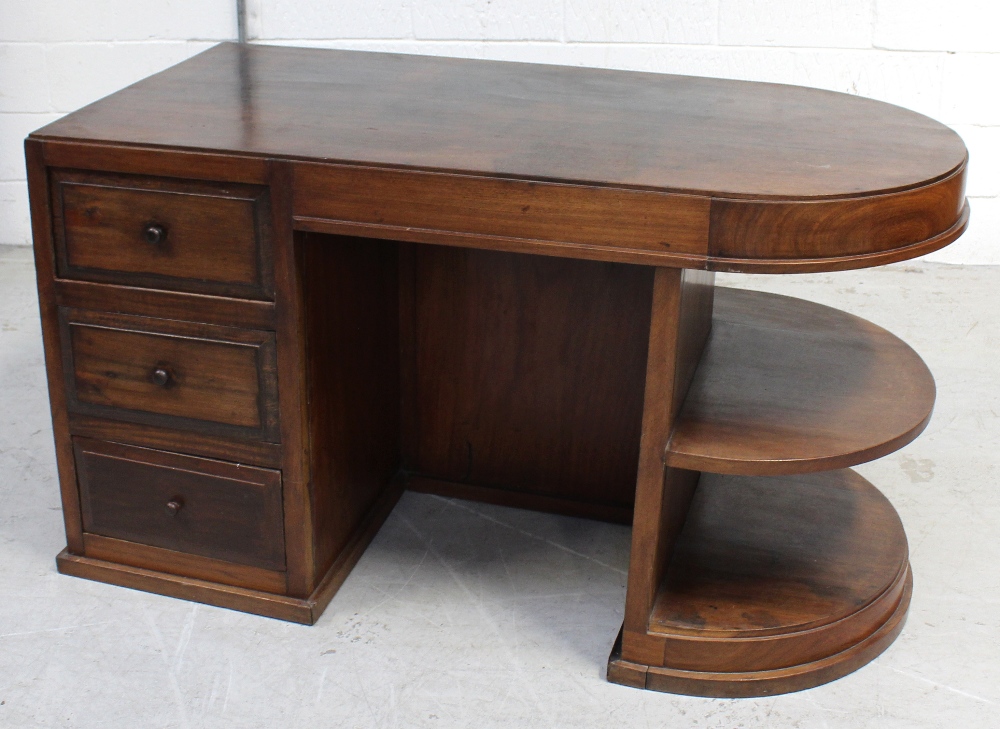 A mahogany kneehole desk with rounded top, three drawers and shelves, width 140cm.