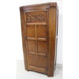 An early-to-mid oak hall robe, single door with raised carved rectangular panel above six panels,