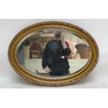 A gilt framed oval bevelled wall mirror, 85x32cm.