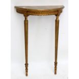 A decorative giltwood demi-lune console table raised on fluted tapering supports, width 63.5cm.