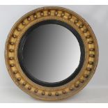 A 19th century circular convex wall mirror with ebonised slip and ball decoration to the frame,