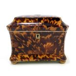 An early 19th century tortoiseshell and ivory two division sarcophagus tea caddy of waisted form,