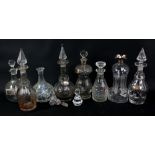 A group of eight various glass decanters, one of waisted form with silver collar,