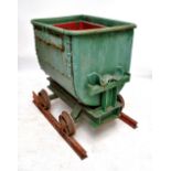 A green painted iron miners cart, height approx 94cm, with two pieces of track.