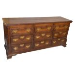 An 18th century oak mule chest, the hinged moulded top above three dummy and six real drawers,