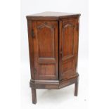 An 18th century oak two door corner cupboard, raised on later stand.