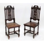 A pair of Victorian carved oak hall chairs with grape and leaf motif backs and foliate carved seats