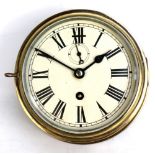 A circular brass ships clock with painted dial set with Roman numerals, diameter 20.5cm.