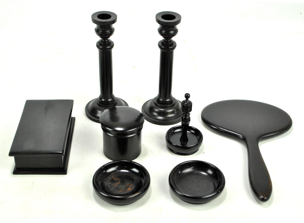 A matched eight piece ebony dressing table set including an oval hand mirror,