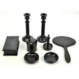 A matched eight piece ebony dressing table set including an oval hand mirror,