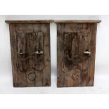 A pair of rustic twin branch wall lights with fluted mask arms supporting simple disc sconces on a