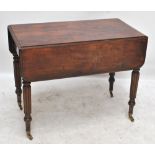 A Regency mahogany Pembroke table with fluted legs on castors, 90 x 94cm when extended.