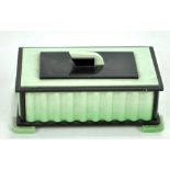 An Art Deco green and black acrylic two section lidded cigarette box with wavy shaped side on