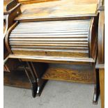 An early 20th century oak roll top desk of small proportions.