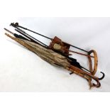 Three early 20th century umbrellas, a malacca walking cane with antler handle,