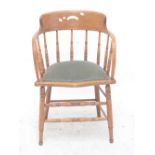 An oak serpentine front spindle bow back elbow chair.