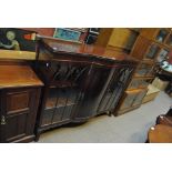 An early 20th century display cabinet with bowfronted cupboard section flanked by glazed door