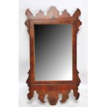 An early 20th century Chippendale style walnut fretwork framed mirror, height 92cm.