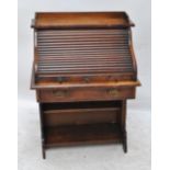 An early 20th century oak roll top desk of small proportions.