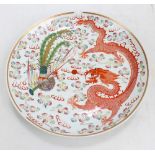 A decorative porcelain charger painted with a five claw dragon and exotic bird,