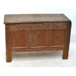 An oak coffer for restoration with three panel front beneath carved frieze, width 107cm (af).