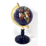A globe with inset semi-precious hardstones and materials on circular base, height 33.5cm.