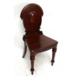 A Regency mahogany hall chair, the top rail with stepped terminals,