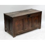 An oak coffer with two plank top and three panel front with carved lozenges beneath carved frieze,